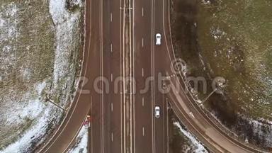空中拍摄的汽车和卡车在一个冬季十字路口与一个大的道路交叉口的顶部视图。 无知的观点