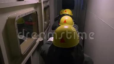 在黑暗隧道进行救援行动，背部观看防护服和黄色头盔的救援。