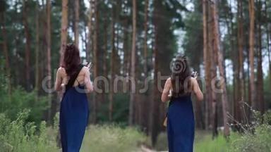 两个女<strong>竖</strong>琴演奏者沿着一条森林之路走开，演奏<strong>竖</strong>琴。