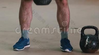 运动训练-一个长着毛茸茸的腿的运动员，双手抱着体重