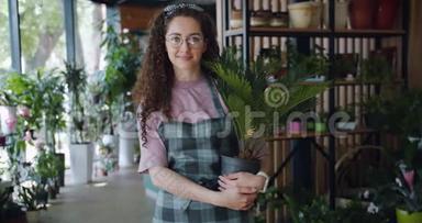 一幅美丽的女子花店站在花店里的异国情调植物画像