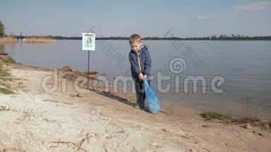 儿童对<strong>垃圾</strong>，儿童男孩在<strong>清理</strong>塑料后在河堤上的标志上拉着沉重的<strong>垃圾</strong>袋