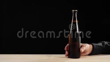 新鲜<strong>啤酒</strong>。 在黑色背景的木桌上，用一瓶棕色的美味工艺<strong>啤酒</strong>递给我。 <strong>冰镇啤酒</strong>