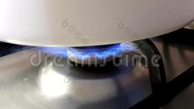 用燃烧的蓝色火焰在煤气炉上盖上一个白色的锅