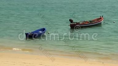 一艘红船和一艘蓝船停泊在海滩上