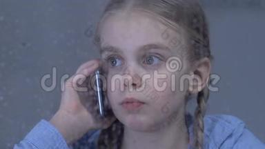 沮丧的女孩在电话中交谈，忍受着孤独，<strong>思念</strong>着被占的父母