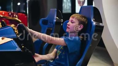 男孩坐在一辆赛车椅子上玩电子游戏。 从侧面看。 这个男孩`脸上流露出情感。