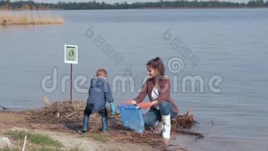 环境问题的解决方案，男孩帮助妇女志愿者积极分子从塑料垃圾清理肮脏的河滨