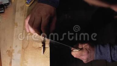 工匠木匠用手锯特写在木梳上做了一个切口。 一个木匠匠人在木须上做了一个切口