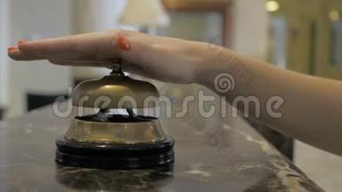 一个年轻女孩在<strong>酒店接待处</strong>使用服务钟的手