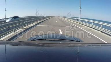在晴朗的天气里，蓝色的汽车在新克里米亚桥上行驶。 照相机安装在蓝色汽车的车顶上
