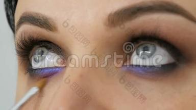 美丽的蓝眼睛是一个年轻的女人，她用特殊的刷子、丁香和珍珠般的<strong>烟熏</strong>眼睛涂着<strong>烟熏</strong>的眼睛