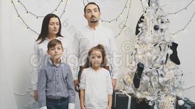 父母和孩子站在圣诞树旁心烦意乱的不堪一击的心情，而圣诞节则是微笑和微笑的时候了