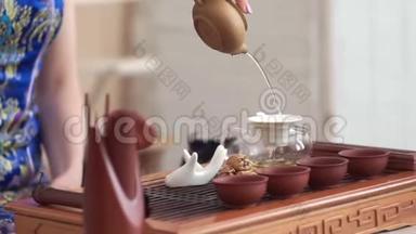 女孩小心翼翼地在小木桌上举行中国茶道