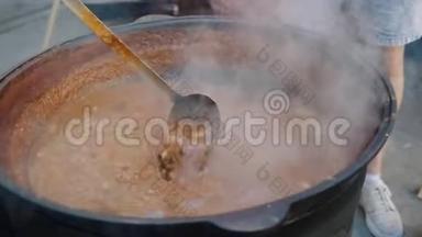 厨师用大锅搅拌汤汁