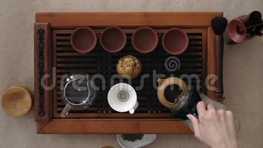 顶景茶具一个木桌，用于茶道背景.. 女孩把开水倒进茶壶里