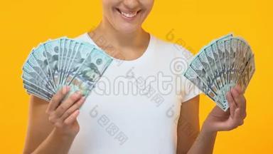 微笑的女人拿着一束钱，成功的<strong>创业项目</strong>，钱