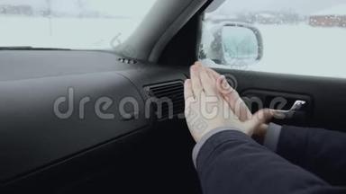 在冬天的白天，车里的人用空调<strong>取暖</strong>器<strong>取暖</strong>。 一个人冻在外面