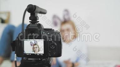 有趣的女孩在家里用数码<strong>相机录制</strong>视频。 博客和社交媒体概念