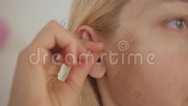 女人用棉签擦耳朵。