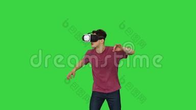 亚马逊人使用VR耳机眼镜触摸和<strong>互动</strong>虚拟现实世界的绿色<strong>屏</strong>幕，Chroma键。