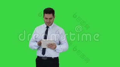 快乐的商人走进来使用平板电脑打开东西或打开东西在绿色屏幕，Chroma键。