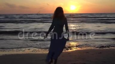 日落<strong>时光</strong>着脚在海滩上散步的美丽女孩<strong>剪影</strong>