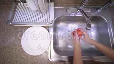 女人正在<strong>厨房</strong>的水槽里用自来水<strong>冲洗</strong>番茄