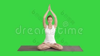 放松的女人在瑜伽的位置，把手放在一起，冥想一个<strong>绿色</strong>的屏幕，Chroma键。