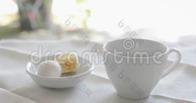 在白色陶瓷杯里喝一杯黑咖啡，在桌上<strong>吃</strong>一个小白<strong>月饼</strong>