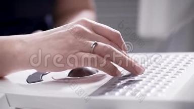 女人按下键盘上的按钮，旋转电脑鼠标球，调整医疗设备