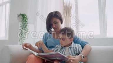 小可爱男孩和妈妈坐在保险箱里看书的肖像。
