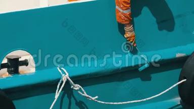 水手的手用油漆涂着<strong>船尾</strong>或<strong>船尾</strong>的滚轴涂着蓝色油漆