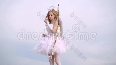 箭和翅膀。 少年丘比特。 快乐的少女天使女孩。 一个穿着天使衣服的孩子在天空背景上。 空间