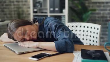 <strong>劳累</strong>了<strong>一天</strong>的年轻女士在工作中躺在笔记本电脑上休息