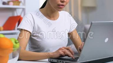 女士自由职业者在笔记本电脑蚂蚁家和吃苹果，健康的零食