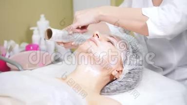 美容师在美容诊所做美容手术，在`客户的面部包装。