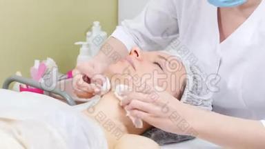 美容师在客户的脸颊上擦奶油`做美容手术，清洁面部美容
