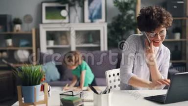 女孩在家玩手机时用手提电脑工作