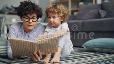 爱看书的妈妈给好奇的小男孩看书，让他在光房子里的地板上放松