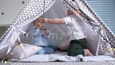 两个孩子在<strong>一</strong>个孩子`帐篷里玩花环。 <strong>一个人</strong>从另<strong>一个人</strong>身上爬开