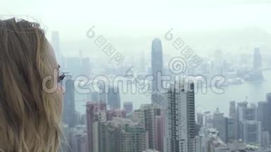 年轻女子从维多利亚峰观看香港城市全景。 白种人肖像旅游妇女观看全景