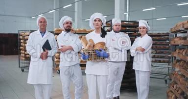 <strong>食品行业</strong>漂亮的面包师女士和她的同事主要团队直视镜头，在一家大面包店微笑