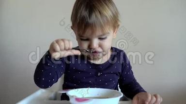 小婴儿学步的孩子独自<strong>用勺子</strong>喝汤。 发育良好的孩子。 食物