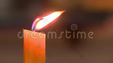 教堂里的蜡烛燃烧着黄色的火焰，火焰闪烁，背景模糊