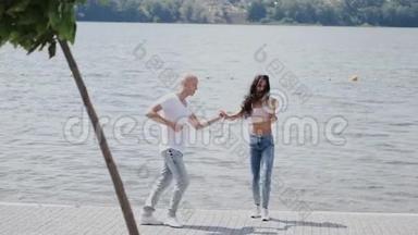 夏日公园里一对情侣在湖边跳舞