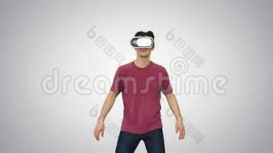 休闲男子在VR眼镜跳舞，玩电子游戏，初学者水平梯度背景。