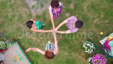 近距离观看年轻人把他们的手<strong>放在一起</strong>。 有着一叠双手的朋友表现出团结和团队合作。