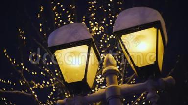 路灯柱上的灯被雪覆盖着，冬天晚上的路灯，下雪的天气