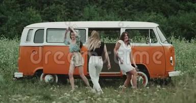 令人惊叹的三位女士在一辆橘色老式货车前的舞蹈中非常有魅力。